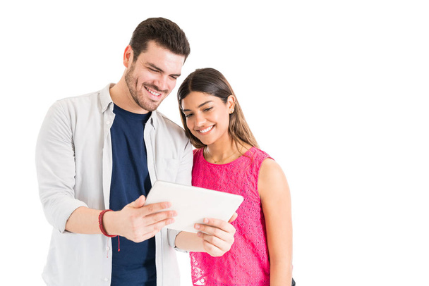 Knappe man het houden van digitale Tablet terwijl staan door vriendin tegen witte achtergrond - Foto, afbeelding