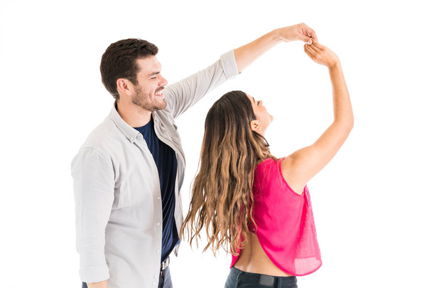 Happy boyfriend and girlfriend enjoying together while dancing in studio - Foto, Imagen