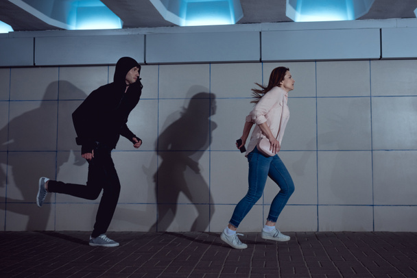 kadın alt geçit hoodie içinde hırsız kaçmak - Fotoğraf, Görsel