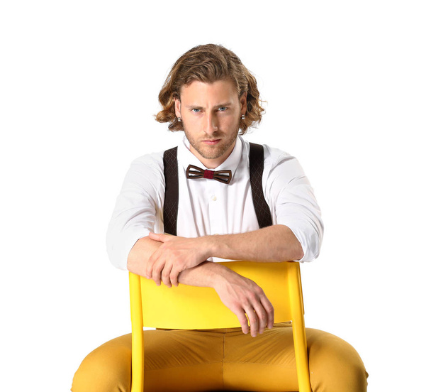 Jeune homme élégant assis sur une chaise sur fond blanc
 - Photo, image