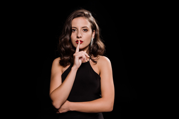 attractive and elegant woman showing hush sign isolated on black  - Fotografie, Obrázek
