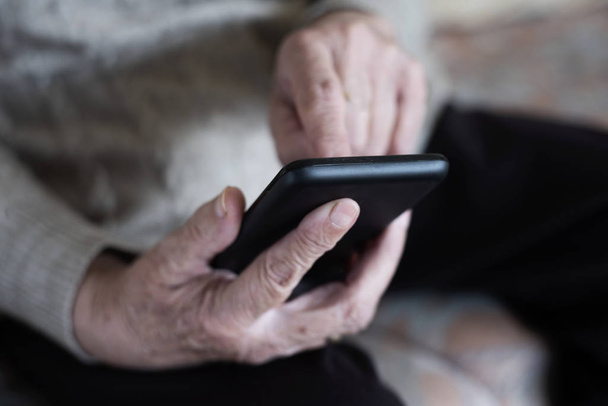 Vanha nainen käyttää älypuhelinta
 - Valokuva, kuva