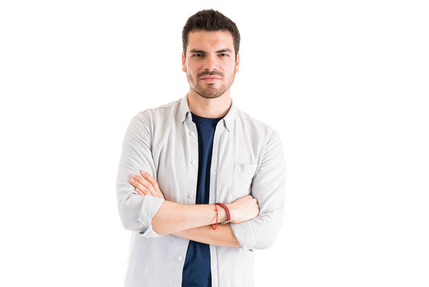Homem atraente confiante de pé vestindo camisa cinza contra fundo branco
 - Foto, Imagem