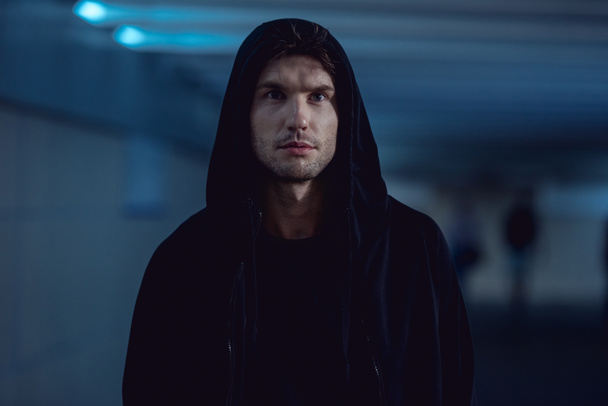selective focus of handsome thief in black hoodie in underpass - Fotó, kép