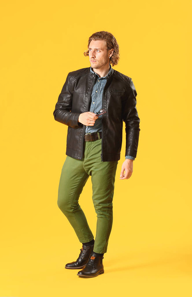 Stylish young man in casual clothes on color background - Foto, afbeelding