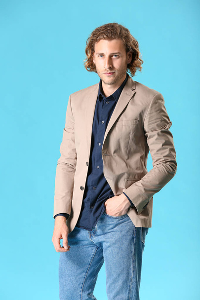 Стильный молодой человек в повседневной одежде на цветном фоне
 - Фото, изображение