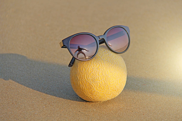 Κίτρινο όμορφο πεπόνι σε γυαλιά, στην παραλία και στη θάλασσα,  - Φωτογραφία, εικόνα