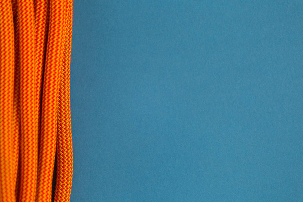 Orangefarbenes Seil zum Klettern auf blauem Hintergrund. - Foto, Bild