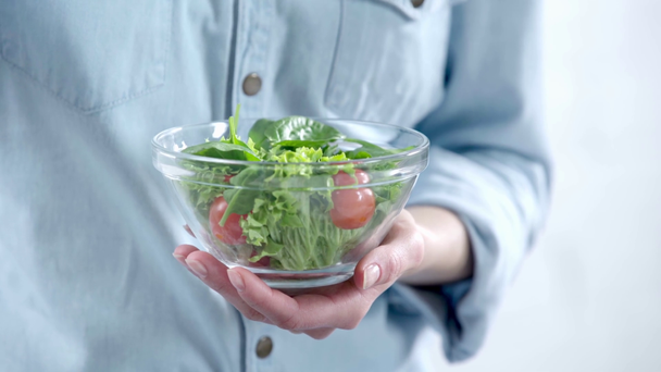 Обрезанный вид женщины, питающейся овощным салатом с вилкой
 - Кадры, видео