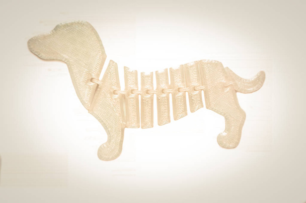 Helder lichtwit object in de vorm van hondenspeelgoed gedrukt op 3d printer - Foto, afbeelding