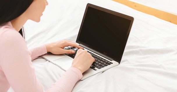 Jeune femme naviguant sur les possibilités de travail sur ordinateur portable
 - Photo, image