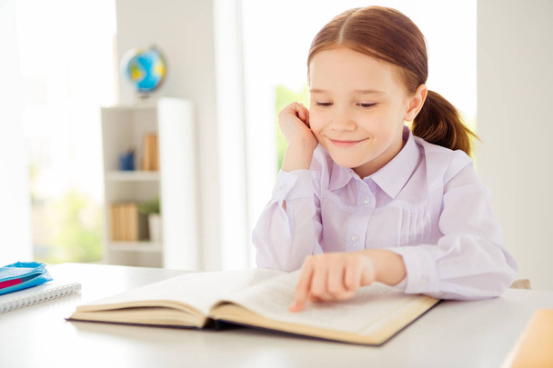Close up photo of adorable focused concentrated kid have materials fantasy book white blouse shirt fashionable modern pigtails ponytails sit class room interior - Foto, Bild