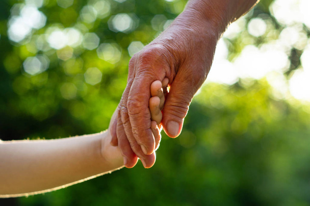 Childs mão e velha mão avó. Conceito ideia de amor família proteger crianças e idosos avó - Foto, Imagem
