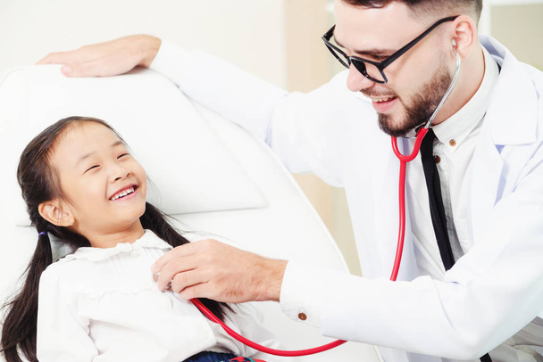 Médico examinando pequeño niño feliz en el hospital
. - Foto, Imagen