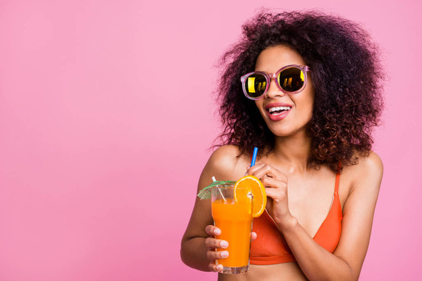 Close up photo beautiful she her dark skin lady enjoy alco non sweet diet beverage hold fingers straw toothy beaming smile cafe bar chill wear sun specs swimming orange suit isolated pink background - Foto, Bild