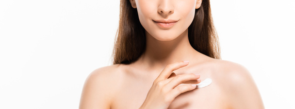 обрізаний вид красивої молодої оголеної жінки з ідеальною шкірою нанесення косметичного крему на шкіру ізольовано на білому
 - Фото, зображення