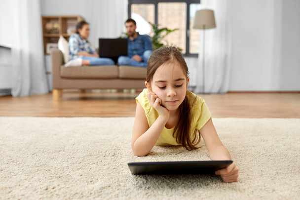 girl with tablet computer lying on floor at home - Photo, Image