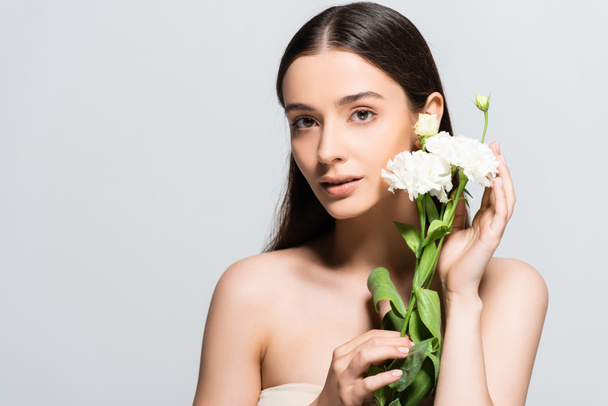 beautiful brunette young woman with white carnations isolated on grey - Фото, изображение