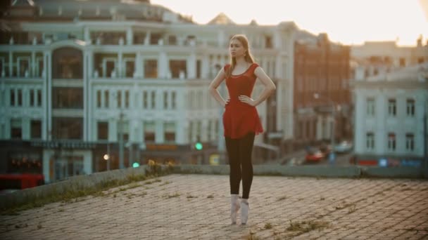 Young woman ballerina training on the roof - standing up and down on the pointe shoes - Footage, Video