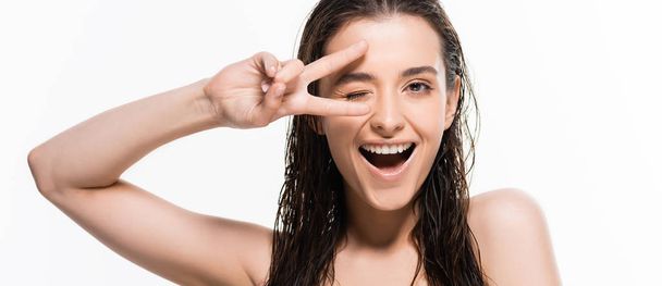 beautiful wet young woman winking and showing peace sign isolated on white, panoramic shot - Photo, Image