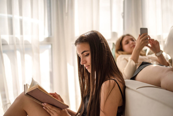 Jonge Kaukasische meisjes ontspannen in de woonkamer - Foto, afbeelding