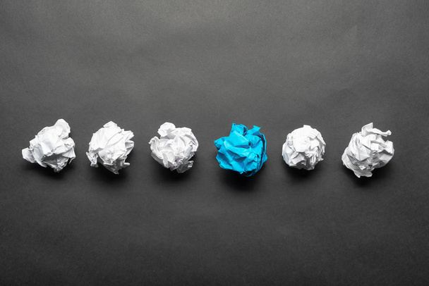 Zdeformená modrá papírová koule mezi bílými míčky - Fotografie, Obrázek