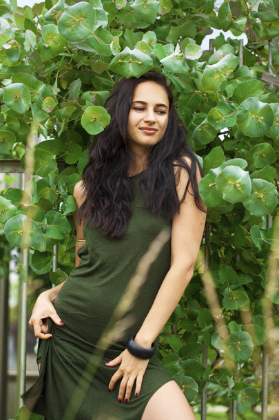Portrait of a young beautiful woman in green foliage - Photo, Image