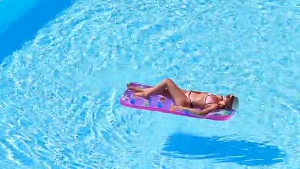 Young woman in bikini air mattress in the big swimming pool - Filmagem, Vídeo
