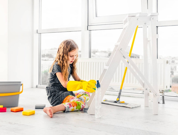 kleines Mädchen schrubbt das Zimmer in Gummihandschuhen - Foto, Bild