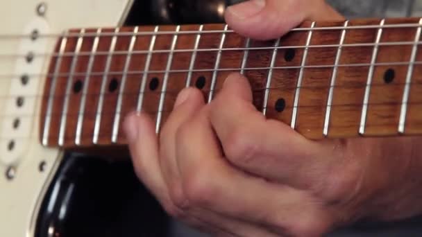 Nahaufnahme der Hand eines Gitarristen auf dem Griffbrett der Gitarre, die zeigt, wie man die Biegetechnik in einem Solo anwendet - Filmmaterial, Video