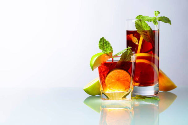 Cocktails à la lime, citron et menthe sur une table en verre
. - Photo, image