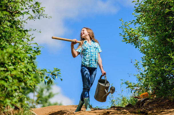 Gardening guide for beginners. Gardening tips. Spring gardening. Girl child hold shovel watering can. Spring gardening checklist. Little helper. Watering tools that will solve dry yard problems - 写真・画像