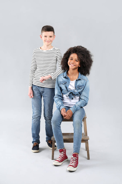 Stylish children in jeans on grey background - Photo, image