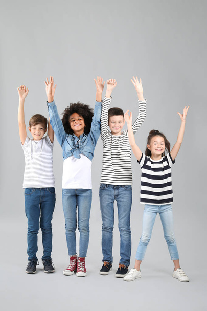 glückliche Kinder in Jeans auf grauem Hintergrund - Foto, Bild