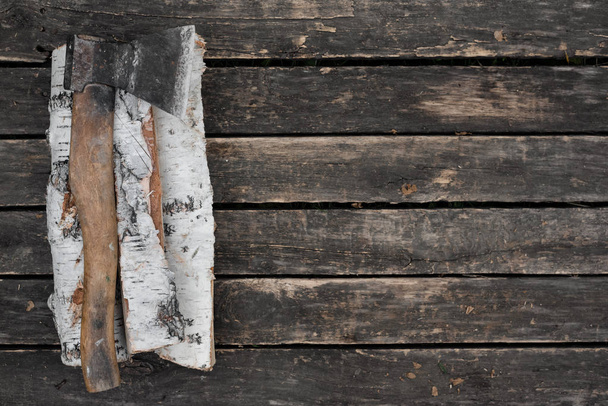 Hatchet and a wooden logs on a wooden floor background with copy space. - Foto, afbeelding