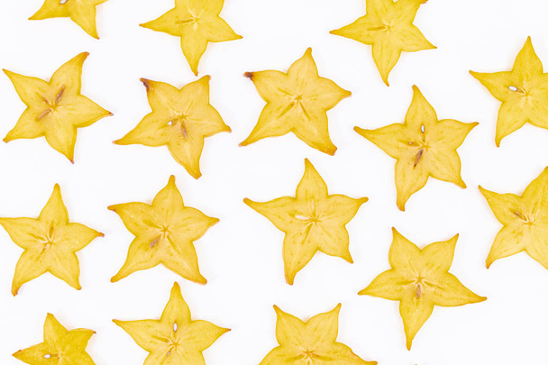 Close up of many slices of star fruit scattered on a white background - Averrhoa carambola - Photo, Image