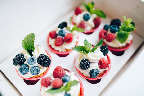 Cupcakes decorated with cream, berries and miny in box. - Foto, Imagem