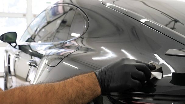 Staff wear Chemical protective clothing at work. Automobile industry. Car wash and coating business with ceramic coating.Spraying the varnish to the car. Concept of: Car protective, Service, Shine. - Foto, Imagen