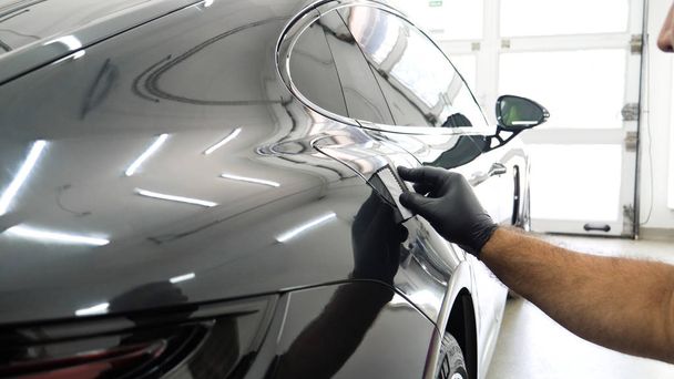 Staff wear Chemical protective clothing at work. Automobile industry. Car wash and coating business with ceramic coating.Spraying the varnish to the car. Concept of: Car protective, Service, Shine. - Foto, afbeelding