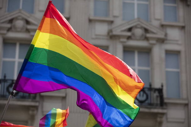 A LGBT gay pride rainbow flag being waved at a pride community celebration event - Фото, изображение