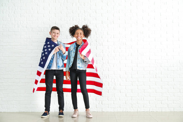Beyaz tuğla duvar a yakın ABD ulusal bayrağı ile Sevimli çocuklar - Fotoğraf, Görsel