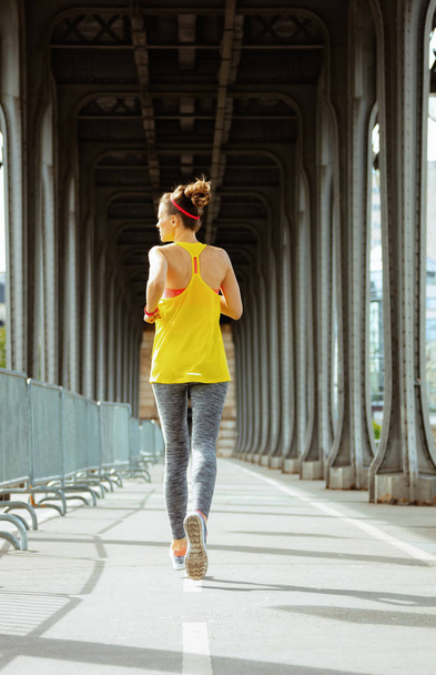 sports woman on Pont de Bir-Hakeim bridge in Paris jogging - Foto, imagen