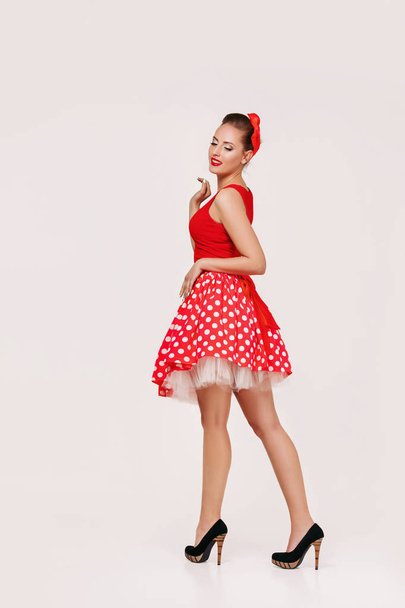 smiling pin up woman in polka dot red dress - Foto, afbeelding