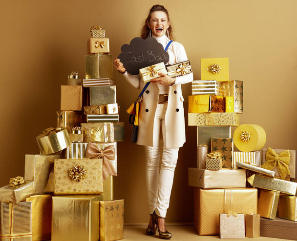 smiling fashion-monger showing present boxes and CashBack sign - Фото, изображение
