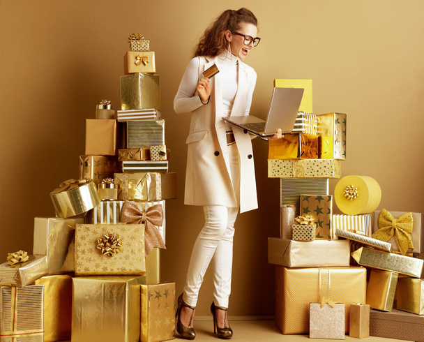 shopper woman with golden laptop and credit card shopping online - Foto, Bild