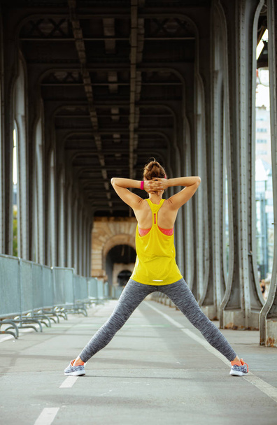 sports woman on Pont de Bir-Hakeim bridge in Paris stretching - Foto, Bild
