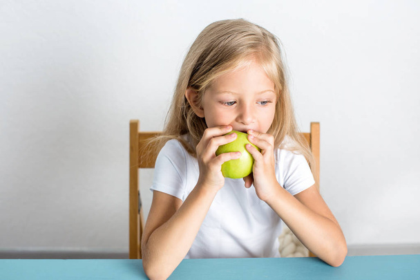 Beautiful girl 7 years old eats an apple - Fotoğraf, Görsel