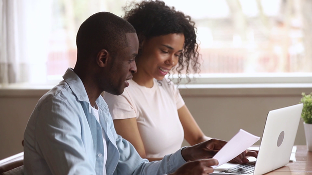 glücklich afrikanisch-amerikanisches junges Paar bezahlt Rechnungen online zu Hause - Filmmaterial, Video