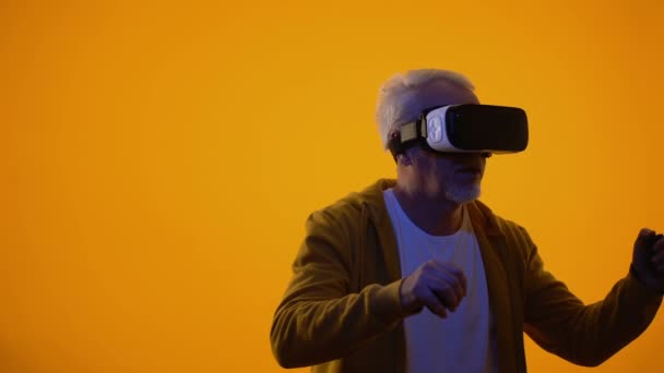 Male pensioner in virtual reality goggles playing videogame, modern technologies - Кадри, відео