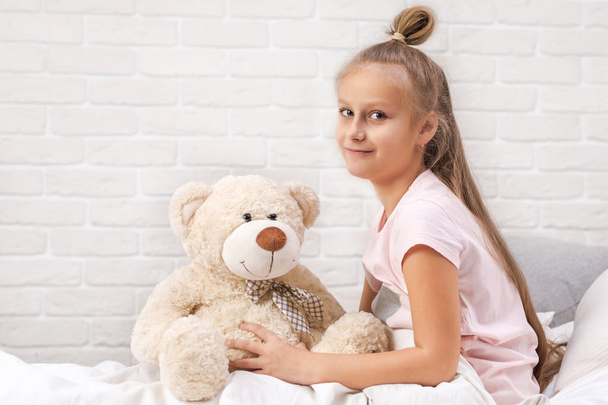 little child girl playing with teddy bear - Foto, afbeelding
